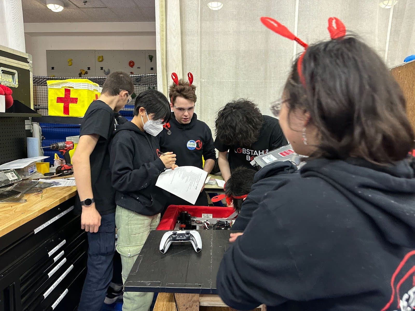 Daniel David '27, Audrey Chuang '27, George Baltus '24, Luke Chang '25, Maxwell Yu '25, and Kendree Chen '25 working on the robot in between matches at the Bridgewater event.