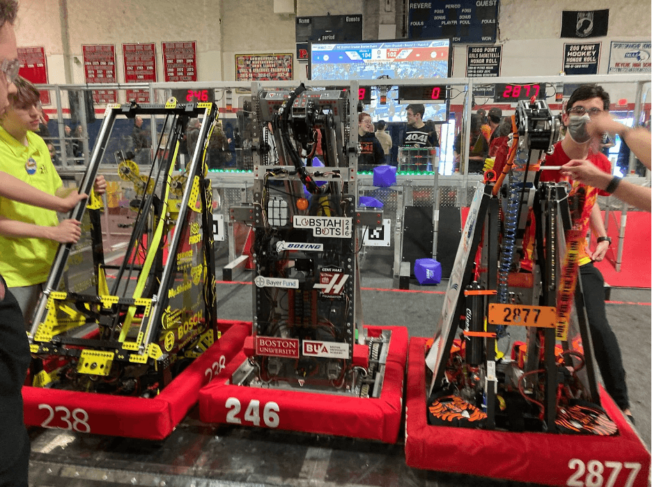 Our Week 4 playoff alliance robots (Team 246 Lobstah Bots in the middle) after making a triple climb onto the charge station at the end of a match.