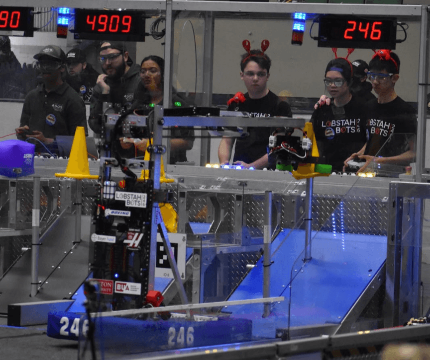 Driver George '24 and operator Maxwell '25 placing a cone on the high node during one of our qualification matches.