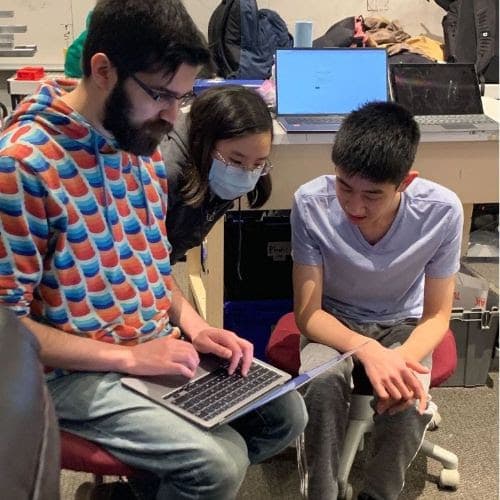 Sam (Mentor) helping students Kendree '25 and Maxwell '25 set up cameras for testing on our old robot.