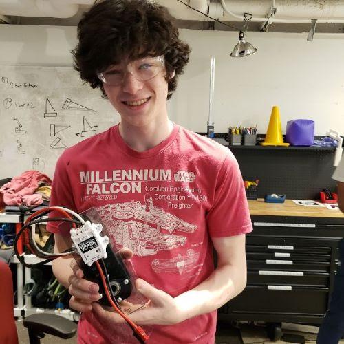 Luke '25 showing off our assembled elevator motor and motor controller which will soon be attached to the robot.