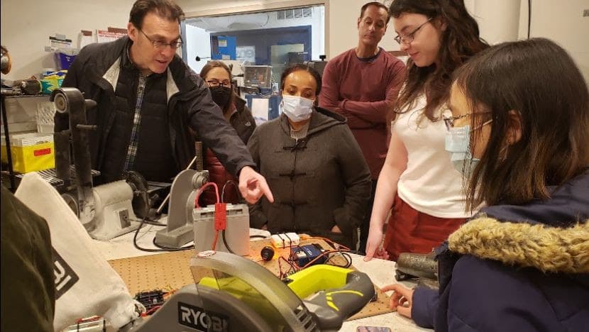 Sonya '24 and Kendree '25 showing the electrical test bench to parents on Saturday’s lab tour.