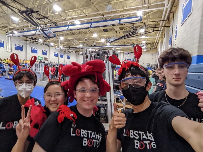 A new rotation of drive team: George '24 (Drive Coach), Maxwell '25 (Operator), Owen '25 (Driver), Kendree '25 (Human Player), Audrey '27 (Technician), and Llama (robot).