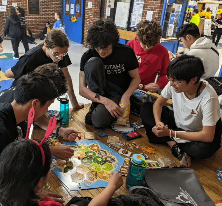 Kendree '25, Nathan '25, Owen '25, Oliver (mentor, '16), Luke '25, Nate '27, and Audrey '27 playing an intense game of Catan during our lunch break.