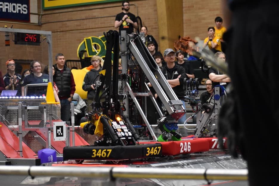 Our robot balancing on the charge station with our two alliance partners at the end of a playoff match.